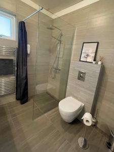 霍芬豪卡贝格旅馆的一间带卫生间和玻璃淋浴间的浴室