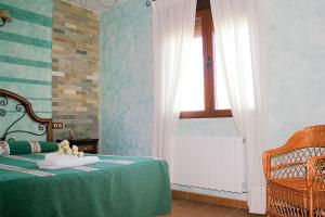 San Pablo de los MontesCasa Rural Cristina III的一间卧室设有一张绿色的床和一个窗户。
