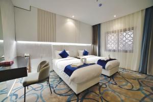 麦地那فندق زوايا الماسية(العوالي)的酒店客房配有两张床和一张书桌