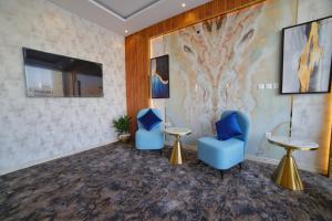 麦地那فندق زوايا الماسية(العوالي)的一间设有2把蓝色椅子和电视的等候室