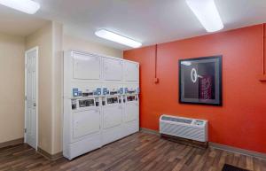 休斯顿休斯顿商业街廊下韦斯特海默购物区美国长住酒店的洗衣房配有白色家电和橙色墙壁