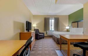 欧文Extended Stay America Select Suites - Dallas - Las Colinas - Meadow Creek Dr的酒店客房,配有一张床、一张桌子和椅子