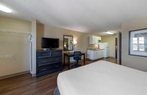 奥兰治亚美利坚长住酒店 - 奥兰治 - 凯特拉大道的一间卧室配有一张床、一台电视和一张书桌
