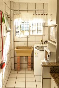 巴拉奈里奥-坎布里乌Apartamento amplo e completo no centro Balneário Camboriú的一个带水槽和窗户的小厨房