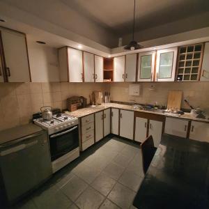科尔多瓦Güemes Hostel Cordoba的厨房配有白色橱柜和炉灶烤箱。