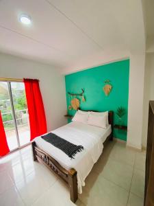 帕洛米诺Casa Guiwa Hostel的一间卧室设有一张大床和绿色的墙壁