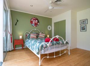 旺阿雷Waimoana Garden Accommodation的一间卧室设有一张床和绿色的墙壁