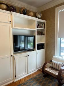 楠塔基特The Centerboard Nantucket的客厅配有白色橱柜和电视。