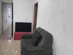 SaubaraCasa laranja cabuçu的客厅里一张沙发,配有电视