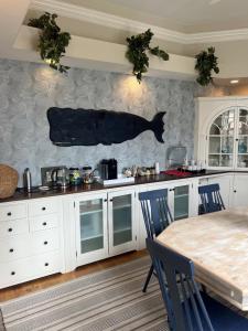 楠塔基特The Centerboard Nantucket的厨房配有桌子和墙上的鱼
