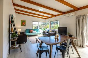 欧尼坦基Onetangi Beach Retreat - Waiheke Holiday Home的客厅配有桌椅