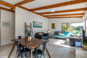 欧尼坦基Onetangi Beach Retreat - Waiheke Holiday Home的客厅配有木桌和椅子