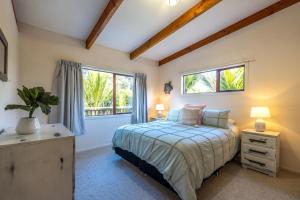欧尼坦基Onetangi Beach Retreat - Waiheke Holiday Home的一间卧室设有一张床和一个窗口