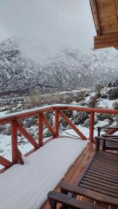 波特雷里约斯Cabaña Rincón del Sol的雪覆盖的甲板上设有长凳和山脉
