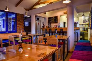 库斯科Saqray Hostel的餐厅设有木桌和紫色椅子