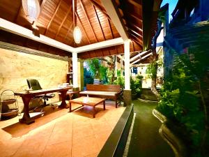 乌布Dupa Ubud的天井设有长凳、桌子和钢琴。