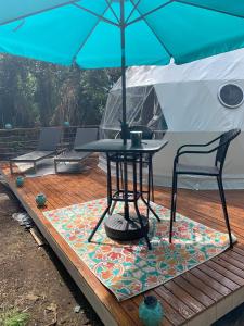 KealakekuaManta Soul Jungle Geodome的甲板上遮阳伞下的桌椅