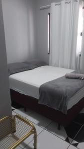 马拉巴Ap. 2 quartos próx. Aeroporto的一间卧室配有两张床和椅子