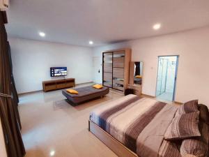 巴淡岛中心Binbaba Homestay - Grand Maganda的一间大卧室,配有一张大床和一张沙发