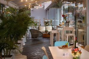 利马利马米拉弗洛雷斯万怡酒店的一间设有白色桌椅的餐厅,种植了植物
