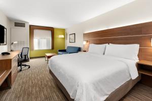 SumnerHoliday Inn Express and Suites Sumner, an IHG Hotel的酒店客房设有一张大床和一张书桌。