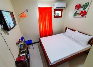 卡加盐德奥罗Downtown Suites CDO的一间卧室配有一张带红色窗帘的床和电视。