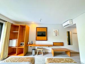 库塔德库塔酒店的客房设有书桌、床和桌子。
