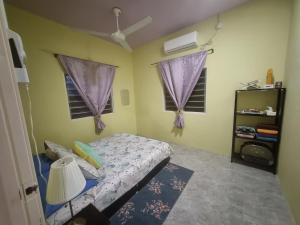 甘榜甘马挽Umar's Tiny House的一间卧室设有一张床和两个窗户。