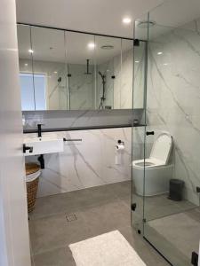 卧龙岗Designer 1 BR Apt in Wollongong with Ocean Views的浴室设有玻璃淋浴间、卫生间和水槽。