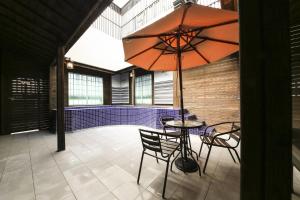 釜山Almond Hotel Gupo Station的庭院配有桌椅和遮阳伞。