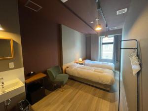 札幌WISE OWL HOSTELS SAPPORO的小房间设有床、水槽和浴室