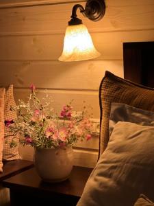 玛尔盖姆拉green island的床头桌旁的一盏灯和一个花瓶