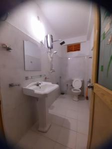 DemoderaArtomoro Ceylon motel的白色的浴室设有水槽和卫生间。