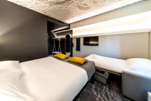 塔林ibis Tallinn Center的配有黄色枕头的酒店客房的两张床