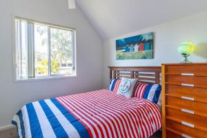 贝拉拉Coral Cottage的一间卧室配有一张床、一个梳妆台和一扇窗户。