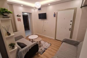 YıldırımCozy 2 bedroom near Green Mosque的客厅配有两把椅子、一张桌子和电视