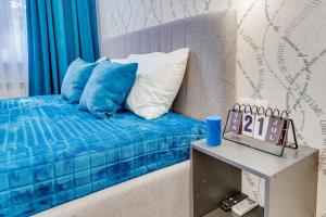 阿拉木图Asaapart Vernyi Room 3的一张带蓝色和白色枕头的床和一张桌子