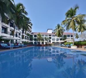 安君纳Fairfield by Marriott Goa Anjuna的一座棕榈树和建筑的大型游泳池