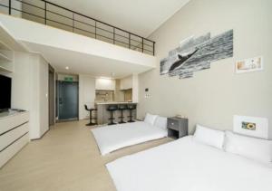 丽水市Coopstay Yeosu Hotel的一间大型客房,设有两张床和厨房