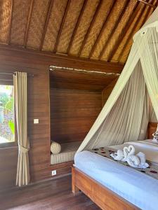蓝梦岛Island Garden Huts Lembongan的卧室配有带窗帘的床
