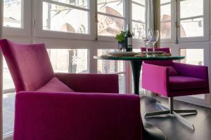 布尔戈斯La Suite de la Catedral by Unique Rooms的一间用餐室,配有紫色椅子和一张桌子