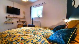AiguilheLe Georges的一间卧室配有一张带五颜六色棉被的床