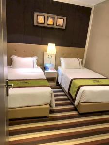 曼谷Capital O 75451 Podstel Hostel Bangkok的酒店客房,设有两张床和一盏灯