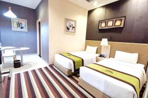 曼谷Capital O 75451 Podstel Hostel Bangkok的酒店客房设有两张床和一张桌子。