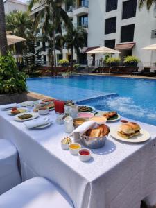 安君纳Fairfield by Marriott Goa Anjuna的游泳池旁的餐桌上放着食物