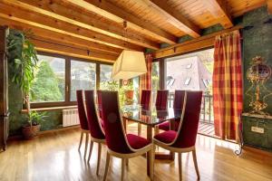 维耶拉Arroquets的一间设有玻璃桌和红色椅子的用餐室
