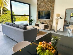 苏梅岛VILLA CAMILLE - SEAVIEW - 4 Bedrooms的客厅配有沙发和水果桌