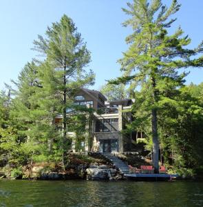 Sainte-Marguerite加拿大风景画家戈登·哈里森艺术家工作坊乡间渡假酒店的湖畔树木的房子
