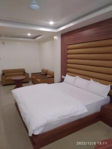 迪马普尔HOTEL NL7的卧室配有一张白色大床和木制床头板