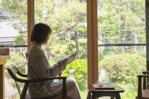 山之内町嘉美浴场旅馆的坐在椅子上靠窗看书的女人